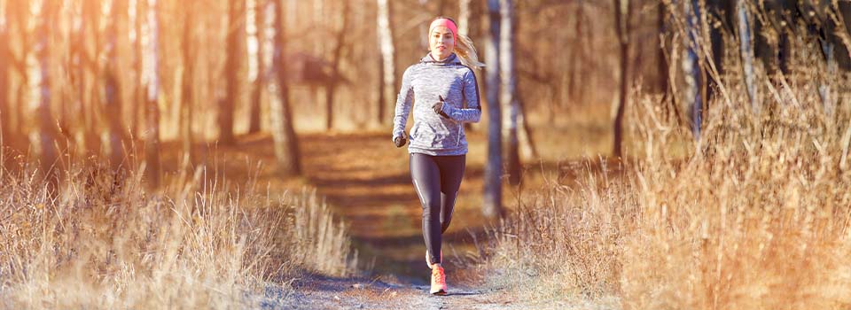 Eine Frau joggt im Herbst.