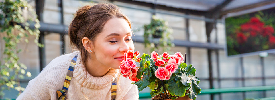Eine Frau riecht an einer Blume.